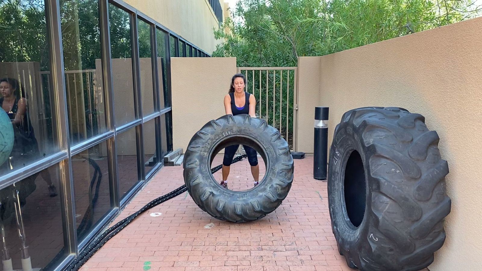 Client flipping a heavy tractor tire during outdoor training